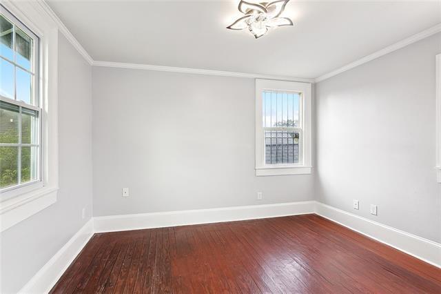 spare room featuring ornamental molding and hardwood / wood-style flooring