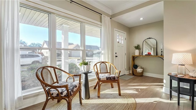 sitting room with light hardwood / wood-style flooring and crown molding