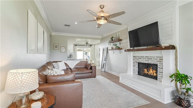 living room featuring a brick fireplace, dark hardwood / wood-style floors, ornamental molding, and ceiling fan