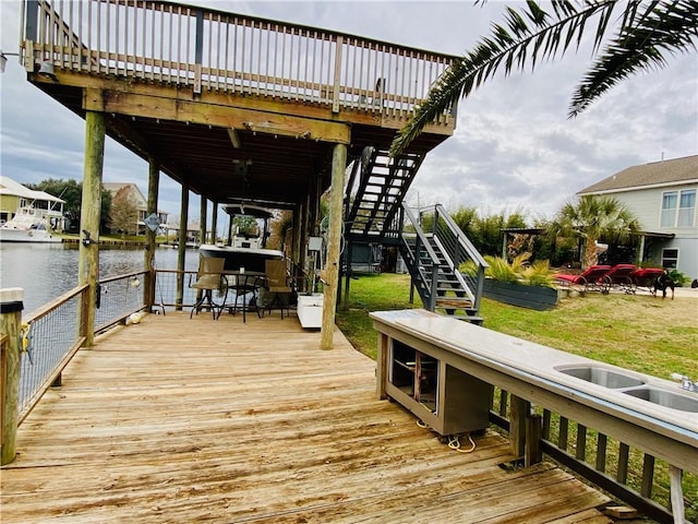 view of dock with a water view and a yard