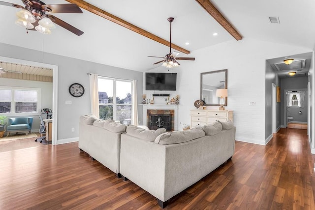 living room with lofted ceiling with beams, ceiling fan, dark wood-type flooring, and a fireplace