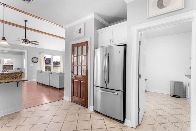 kitchen featuring stainless steel refrigerator, white cabinetry, dark stone countertops, and light tile patterned floors