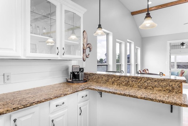 kitchen featuring hanging light fixtures, vaulted ceiling with beams, and white cabinets