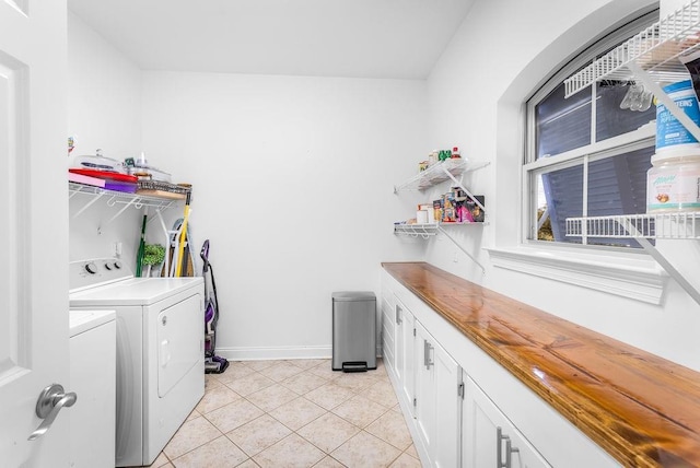 washroom featuring light tile patterned floors and washer and clothes dryer