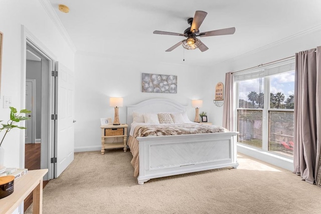 carpeted bedroom featuring ornamental molding and ceiling fan