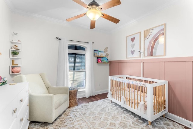 bedroom featuring ceiling fan, ornamental molding, and a crib