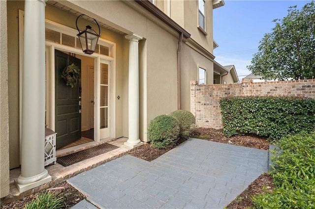 1207 Rue Degas, Mandeville, LA 70471 - property entrance with stucco siding and a patio