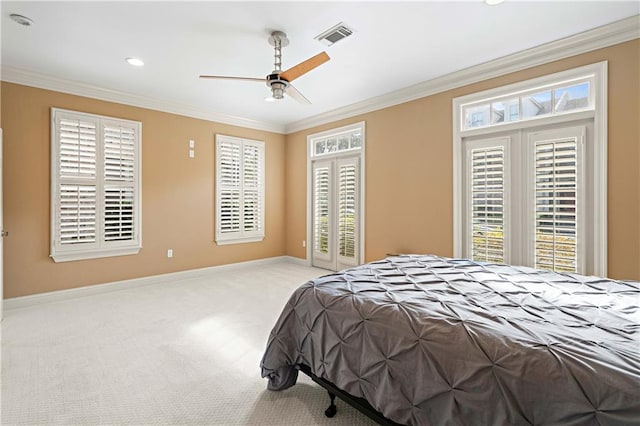 bedroom with ceiling fan, light colored carpet, and multiple windows