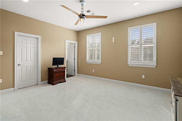 bedroom featuring ceiling fan, multiple windows, and light carpet