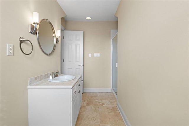 bathroom with a shower with shower door and vanity