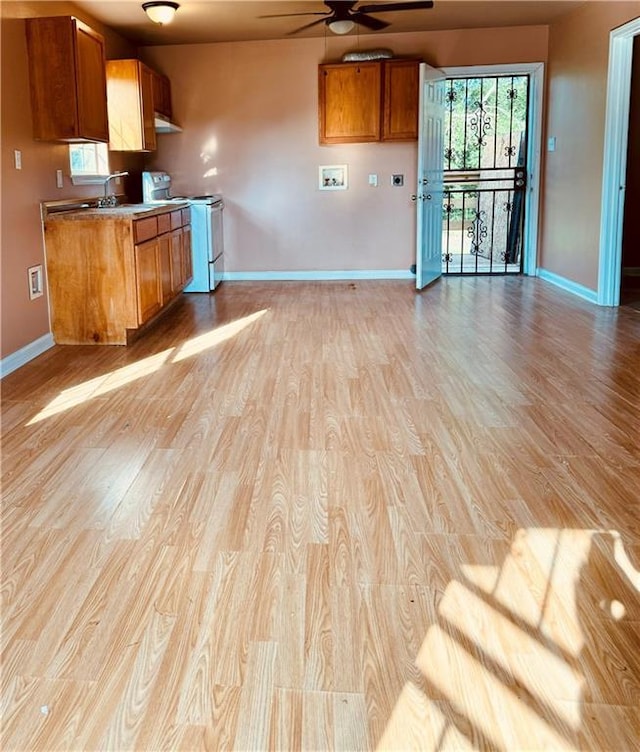 kitchen with sink, ceiling fan, light hardwood / wood-style floors, and electric stove