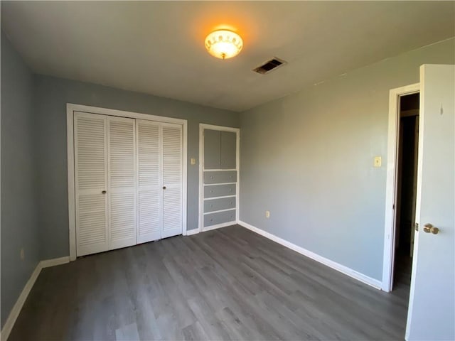 unfurnished bedroom with hardwood / wood-style floors and a closet