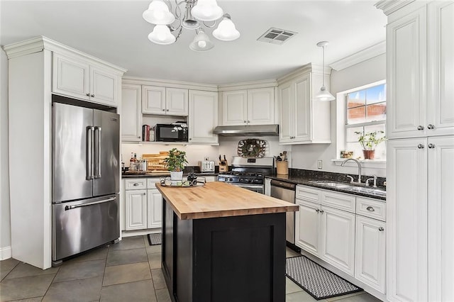 kitchen featuring visible vents, a sink, under cabinet range hood, appliances with stainless steel finishes, and wood counters