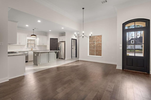 entryway with a notable chandelier, hardwood / wood-style floors, sink, and crown molding