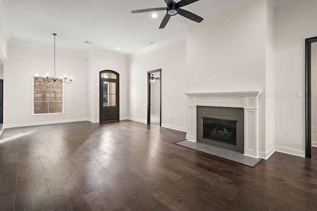 unfurnished living room with dark wood-type flooring, ceiling fan with notable chandelier, and ornamental molding