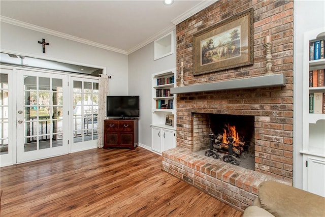 unfurnished living room featuring built in shelves, ornamental molding, hardwood / wood-style floors, and a fireplace