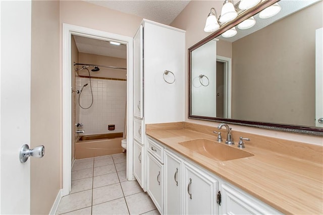 full bathroom featuring tile patterned floors, tiled shower / bath combo, toilet, a textured ceiling, and vanity