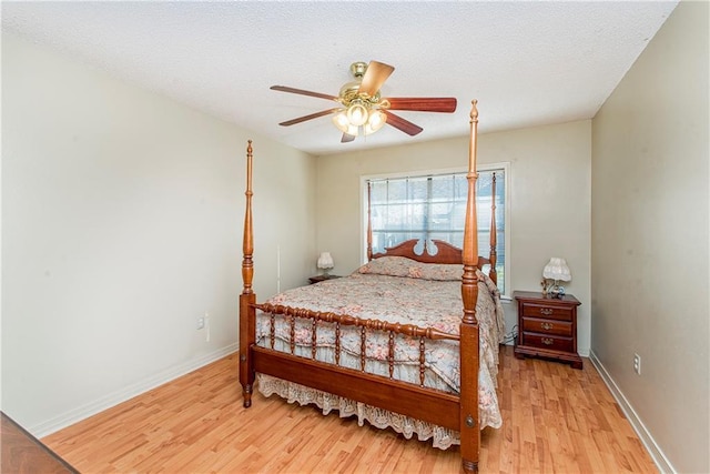 bedroom featuring ceiling fan, a textured ceiling, and light hardwood / wood-style flooring