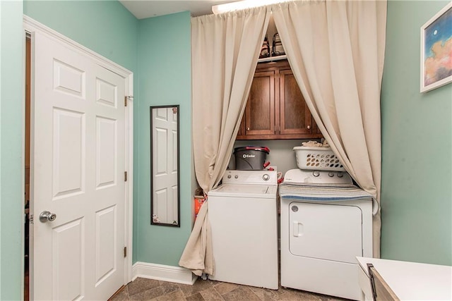 clothes washing area with cabinets and independent washer and dryer