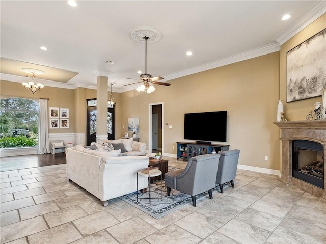 living room featuring ceiling fan with notable chandelier and ornamental molding