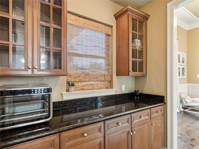 kitchen with crown molding, hardwood / wood-style flooring, and dark stone countertops