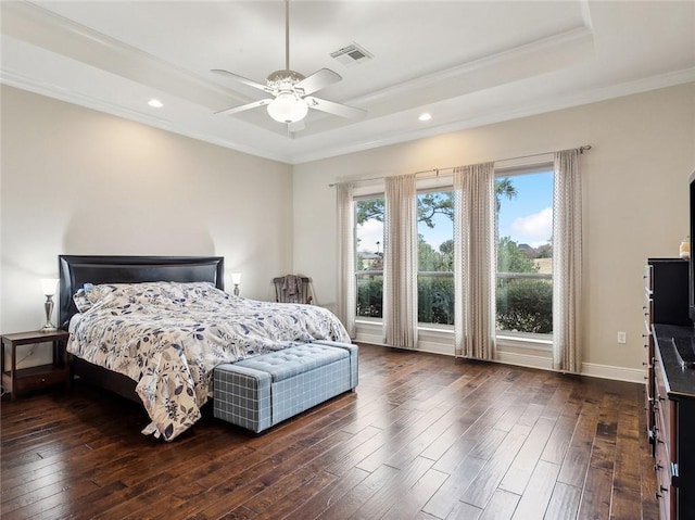 bedroom with ceiling fan, dark wood-type flooring, crown molding, and a raised ceiling