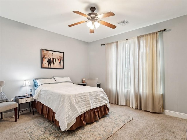 bedroom with ceiling fan, light colored carpet, and multiple windows