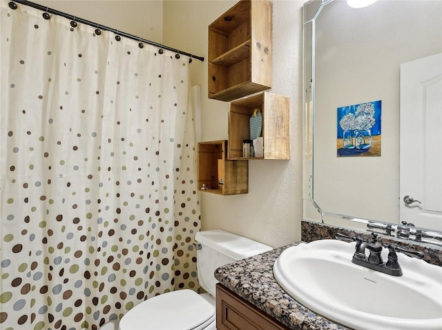 bathroom with toilet, vanity, and a shower with shower curtain