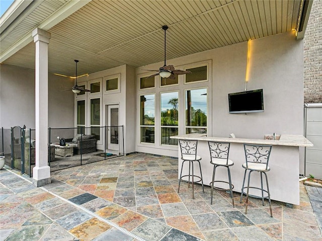 view of patio with ceiling fan, outdoor lounge area, and a bar