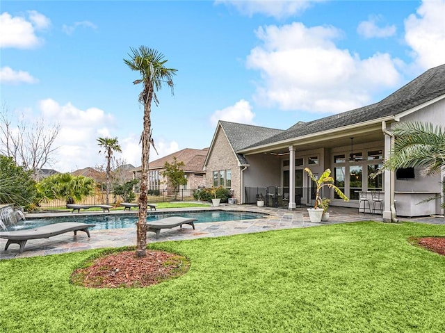 view of pool with a diving board, a yard, and ceiling fan