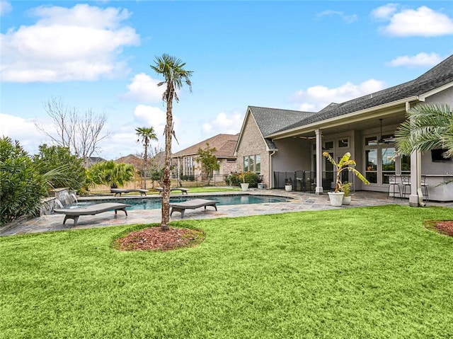 view of pool featuring ceiling fan, a patio area, and a lawn