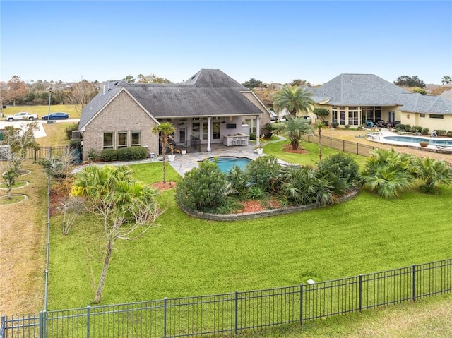 rear view of property with a fenced in pool, a yard, and a patio