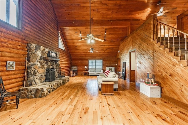 unfurnished living room featuring stairs, a fireplace, hardwood / wood-style floors, and ceiling fan