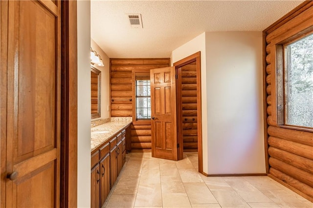 bathroom with vanity, baseboards, visible vents, and a textured ceiling