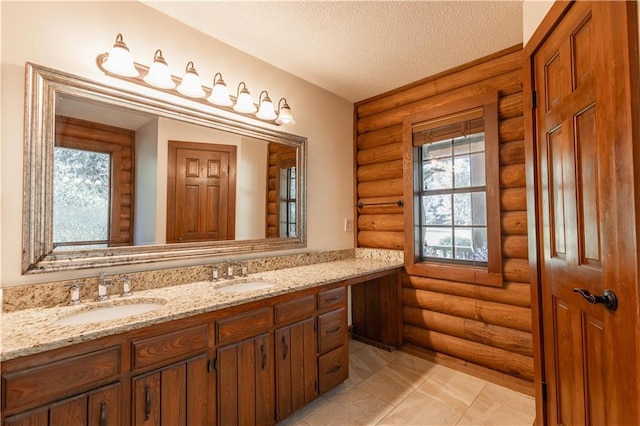 bathroom with a textured ceiling, double vanity, and a sink