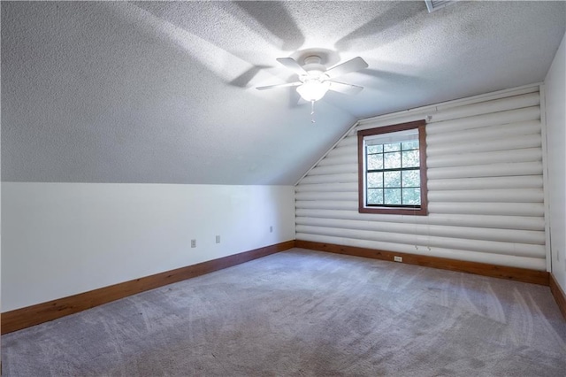 additional living space with baseboards, carpet floors, vaulted ceiling, a textured ceiling, and rustic walls