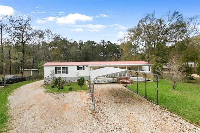 manufactured / mobile home with a carport and a front yard