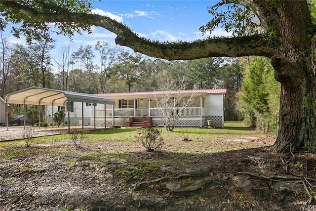 back of property featuring a lawn, a carport, and covered porch