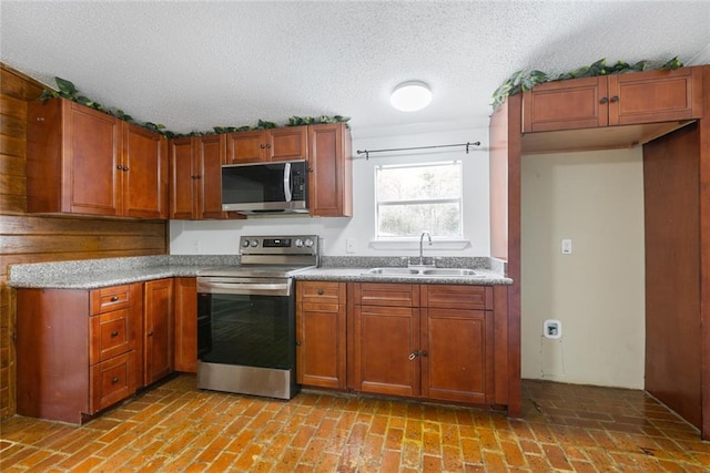 kitchen featuring stainless steel appliances, sink, and a textured ceiling