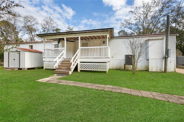 back of house featuring a storage shed, a deck, and a lawn