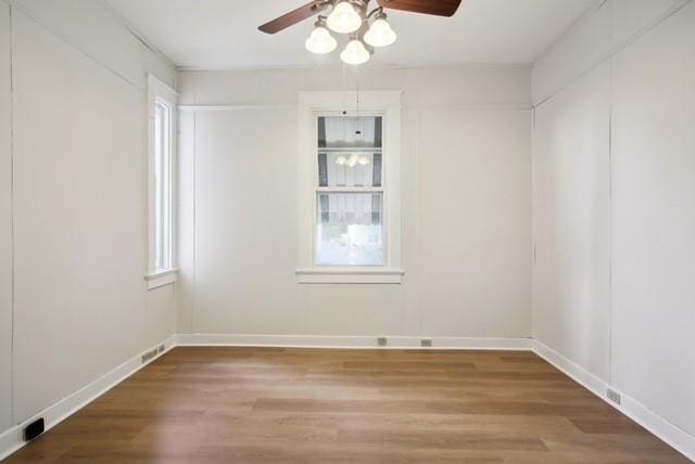 spare room with hardwood / wood-style flooring, a healthy amount of sunlight, and ceiling fan