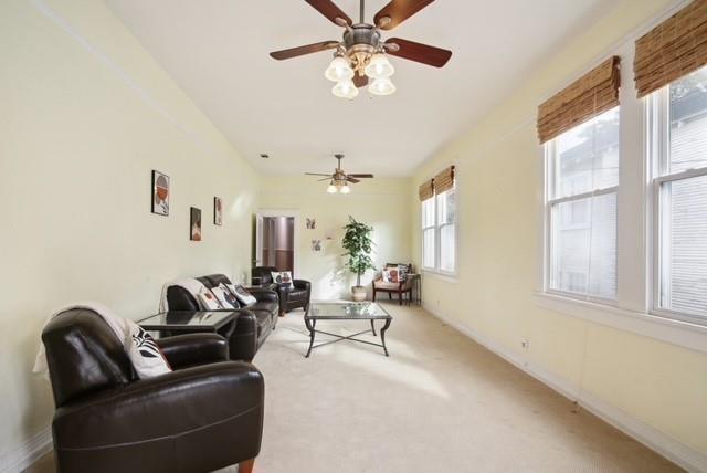 4937-39 S Miro St, New Orleans, LA 70125 - living room with light carpet, baseboards, and ceiling fan