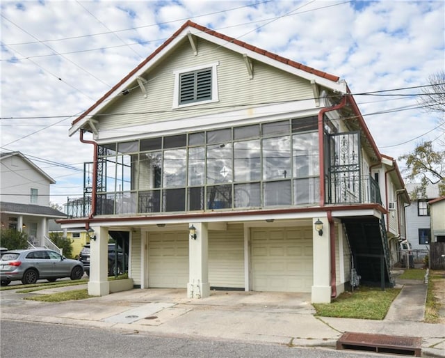 4937-39 S Miro St, New Orleans, LA 70125 - view of front of home with concrete driveway, an attached garage, and a sunroom