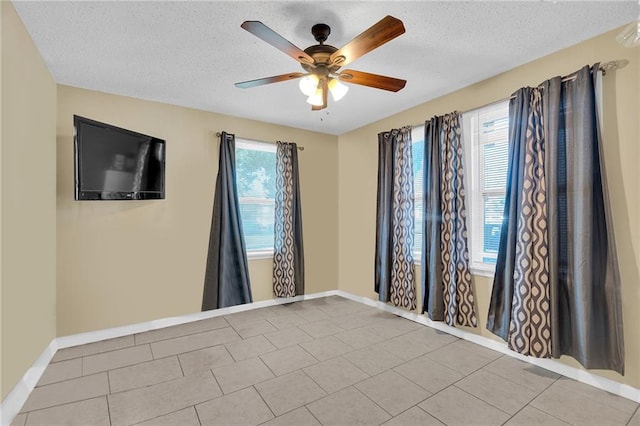 tiled spare room featuring ceiling fan and a textured ceiling