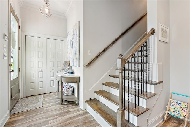 foyer entrance with light hardwood / wood-style flooring and ornamental molding