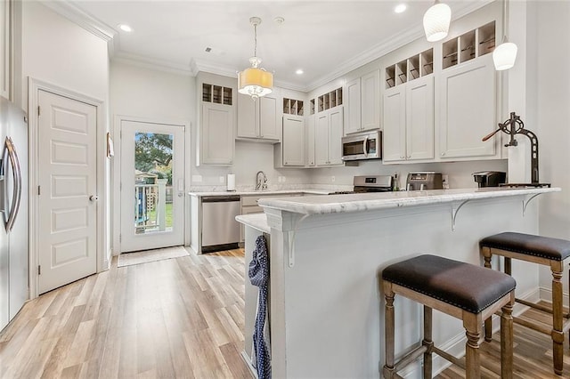 kitchen featuring kitchen peninsula, white cabinets, hanging light fixtures, and stainless steel appliances