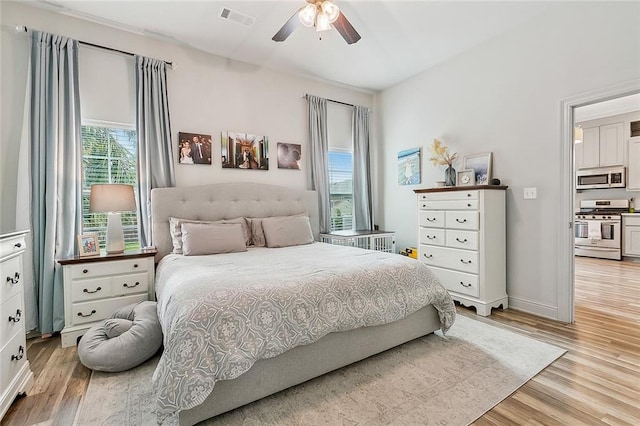 bedroom with multiple windows, light hardwood / wood-style flooring, and ceiling fan