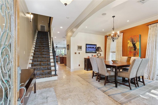 dining area featuring ornamental molding and a notable chandelier