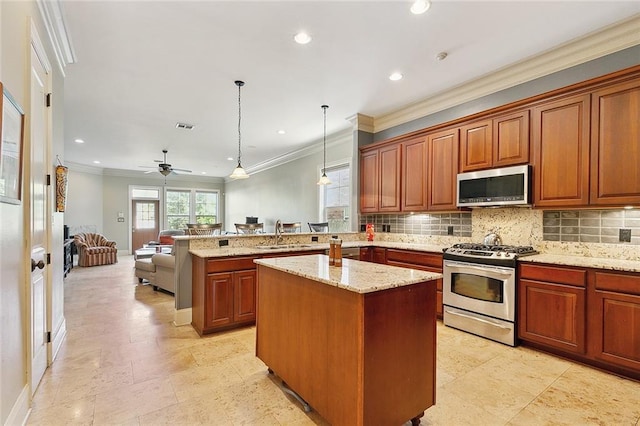 kitchen featuring appliances with stainless steel finishes, decorative light fixtures, kitchen peninsula, and backsplash