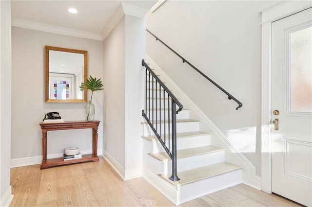 staircase featuring ornamental molding and wood-type flooring